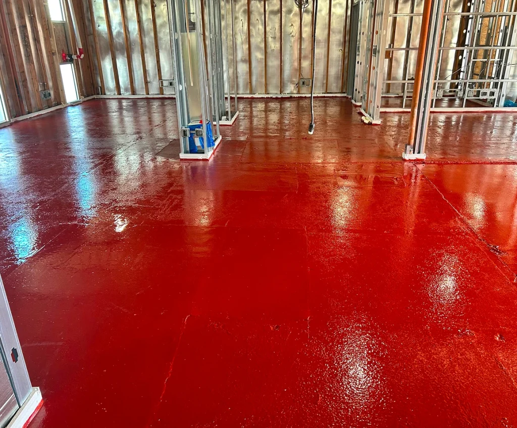 Building interior with red moisture mitigation coating on floor
